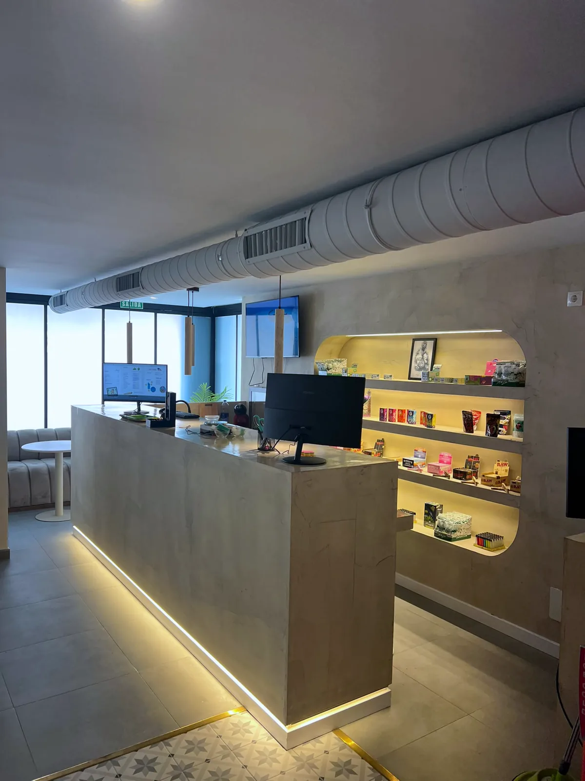 The dispensary counter, with lit shelves behind it and the sofas by the window