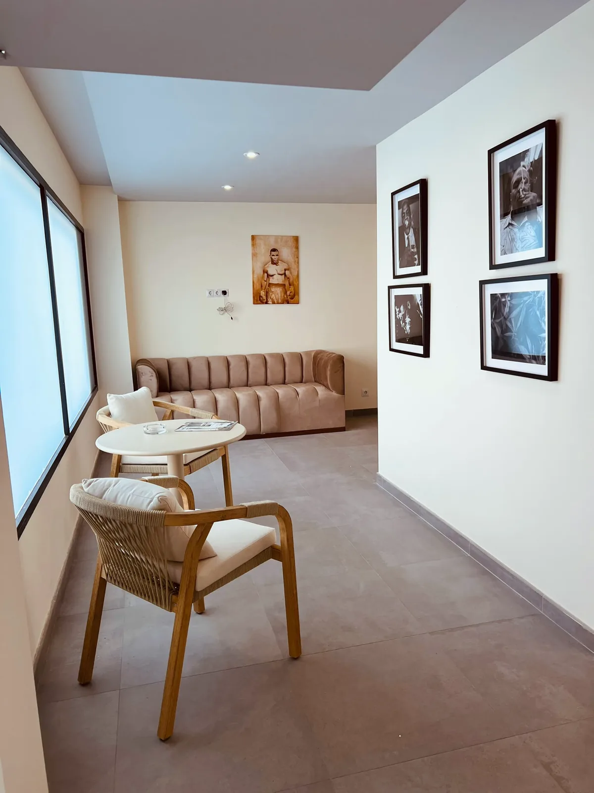 A quiet corner with a velvet sofa, a small table and framed black-and-white prints